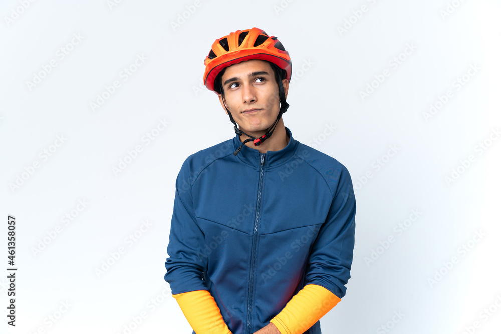 Young cyclist man isolated on background and looking up