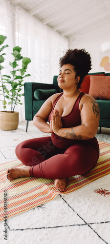 Body positive female practicing yoga meditation at home