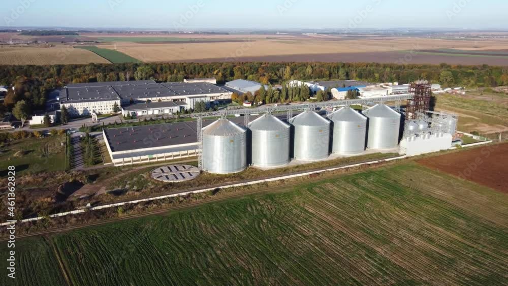 Agro-industrial complex and large modern granary view from a height. Metal barrels of the grain dryer Agro-industrial complex and large modern granary view from a height. Metal barrels of the grain dryer
