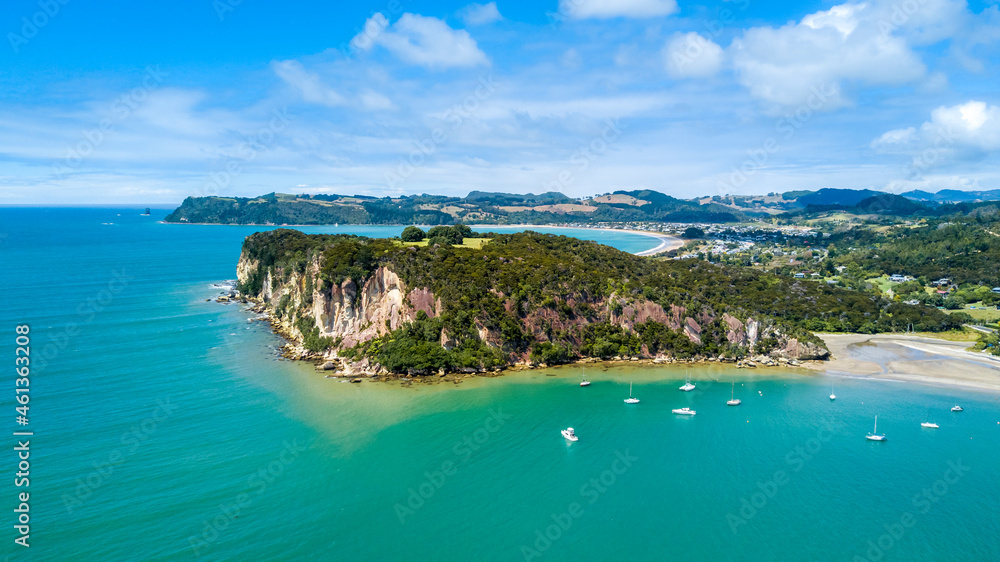 Aerial view on a rocky cliff with a beautiful harbour on the background. Coromandel, New Zealand.