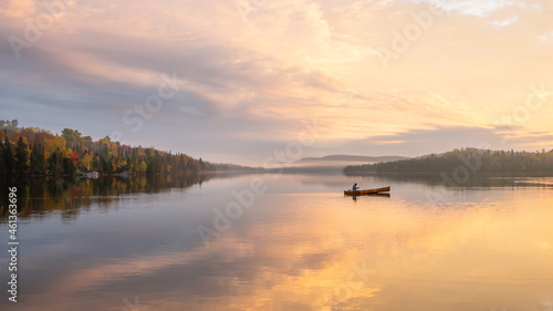 People are boating on Caribou Lake on a fogy morning