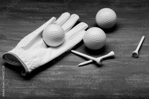 Ladies' golf glove with ball on it, 2 more on a black background and 3 wooden supports to be nailed on the golf course.