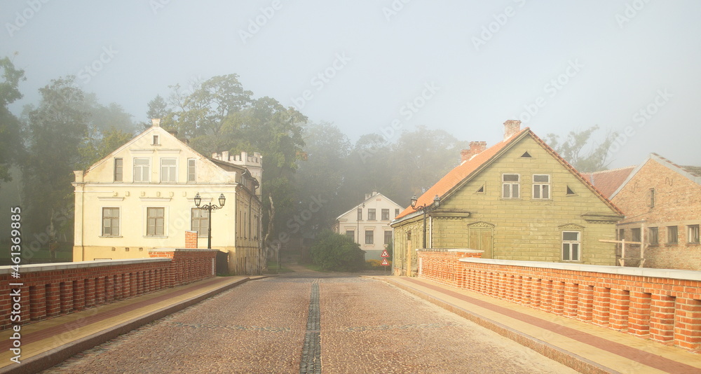Red brick bridge, old historical hauses and mist in Kuldiga, Latvia.
