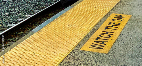 Watch the Gap safety or caution notice on train platform with textured yellow stripe and tracks. Use for retirement or savings insecurity, wage gap, diversity, inequity, college gap year  photo