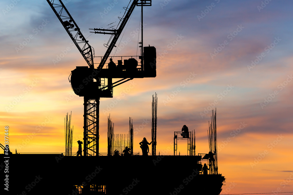 Silhouette of Engineer and worker with clipping path checking project at building site background, construction site at sunset in evening time