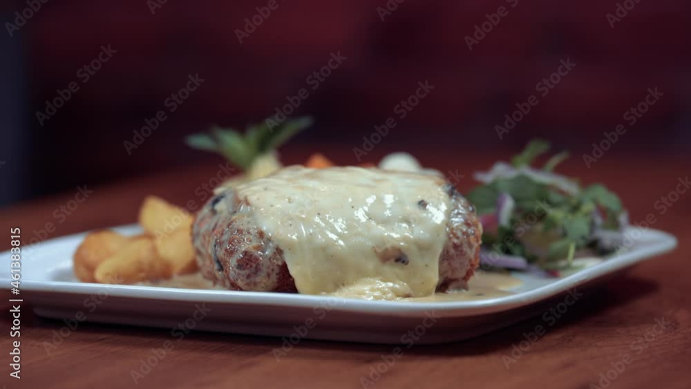 Cordon Bleu with cheese meal on a wooden table with rice and potatoes with beautiful garnish 4k Cordon Bleu with cheese meal on a wooden table with rice and potatoes with beautiful garnish 4k