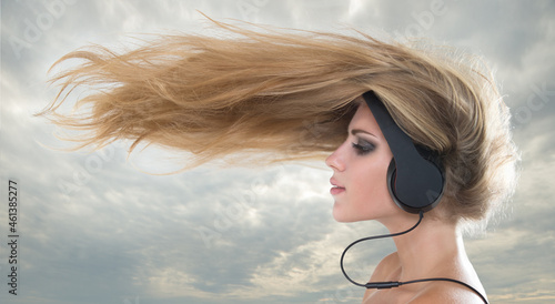 Photography Young woman  listening to music on headphones wind nazvivaet hair