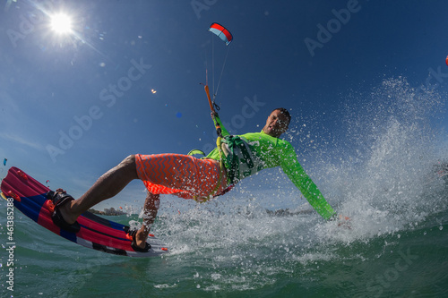 Kite surfer riding a kiteboard on the sea with splash 
