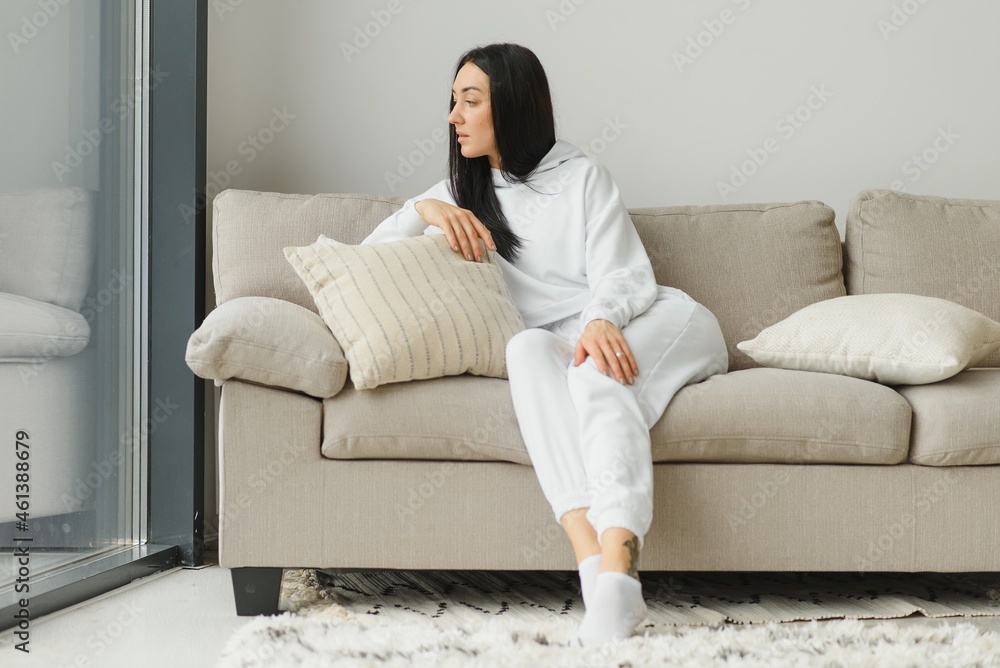 Happy woman relaxing on comfortable soft sofa enjoying stress free weekend at home, calm satisfied girl stretching on couch thinking of pleasant lazy day, dreaming and planning sunday morning Happy woman relaxing on comfortable soft sofa enjoying stress free weekend at home, calm satisfied girl stretching on couch thinking of pleasant lazy day, dreaming and planning sunday morning
