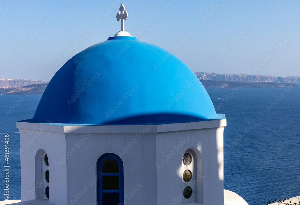 View from viewpoint of Oia village with blue dome of  greek orthodox Christian church. Santorini, Greece