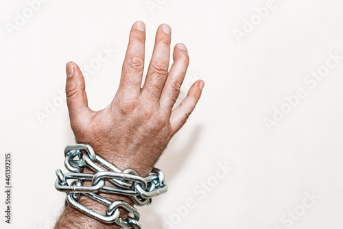 Hand with chain hang,chain in hand,the chain wound on the hand,gray background.Selective focus,copy space. photo