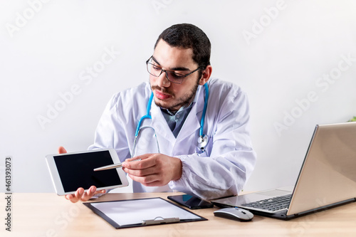 Doctor using digital tablet at his clinic.