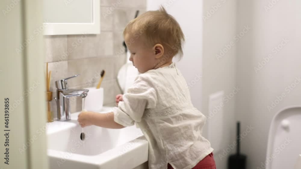 Cute caucasian baby toddler brushing teeth in the bathroom, baby hygiene and independence concept. Natural bamboo toothbrush Cute caucasian baby toddler brushing teeth in the bathroom, baby hygiene and independence concept. Natural bamboo toothbrush