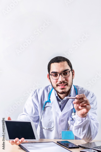 Confident doctor sitting at his clinic desk