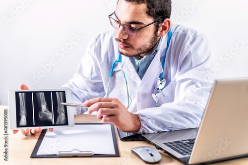 Doctor examining x-ray images on tablet.