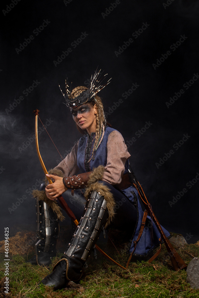 Beautiful female viking woman warrior in battle with bow. Ancient times. Amazon fantasy girl