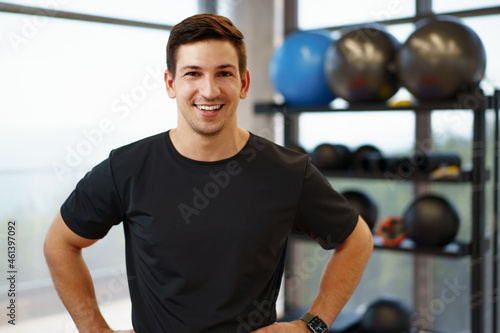 Portrait of a young handsome fitness trainer in a gym