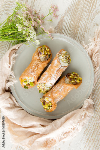 flat lay of plate with italian dessert canolli on a light table photo