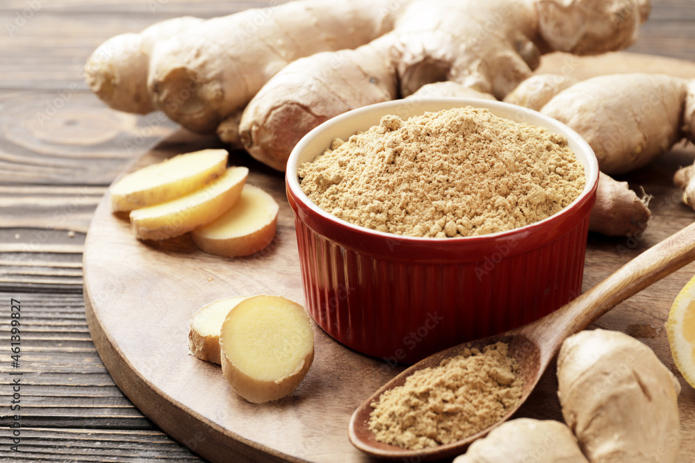 Fototapeta premium Lots of fresh and grated ginger on a wooden background.