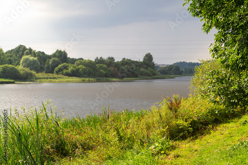 A beautiful view of the peaceful river. Sunny  summer day at the river in rural countryside.