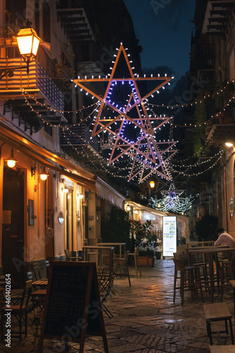 Christmas star lights and festive garlands decorating Orologio street in Palermo, Sicily, Italy
