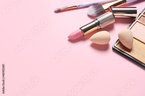 Stylish makeup sponges and decorative cosmetics on color background