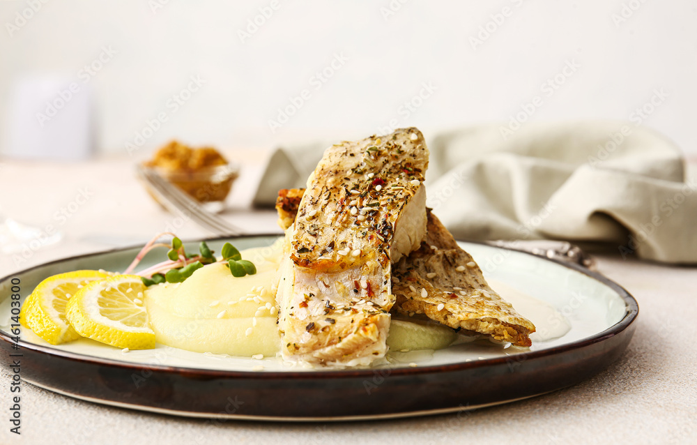 Plate with baked cod fillet, sauce and mashed potatoes on table in restaurant Plate with baked cod fillet, sauce and mashed potatoes on table in restaurant