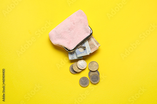 Pink wallet with money on yellow background photo