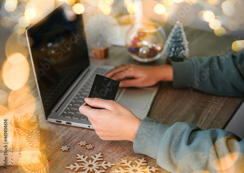 Christmas online shopping for gifts, laptop, credit card and New Year decorations on the table