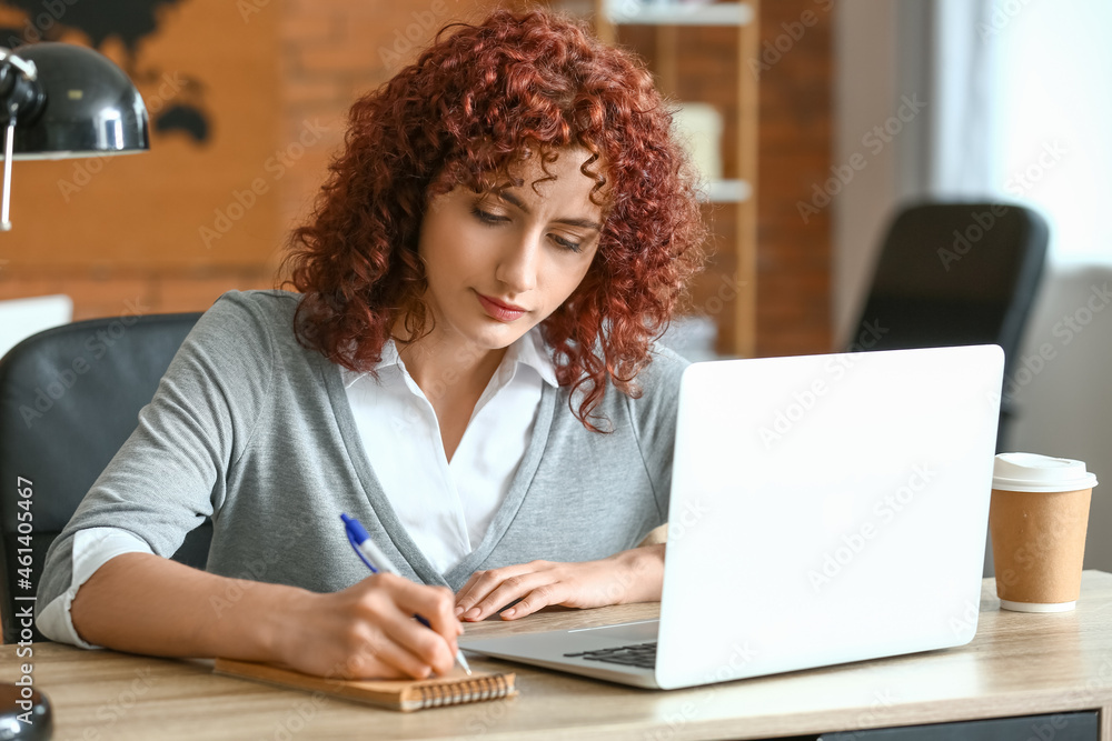 Young woman writing notes during online job interview at home Young woman writing notes during online job interview at home