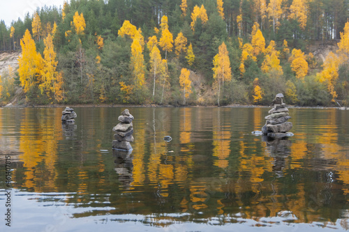 Pyramid of balanced zen stones, yellow and green trees, autumn and peace photo