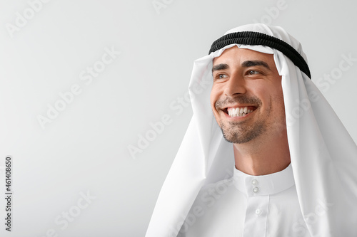 Young Muslim man on grey ba...