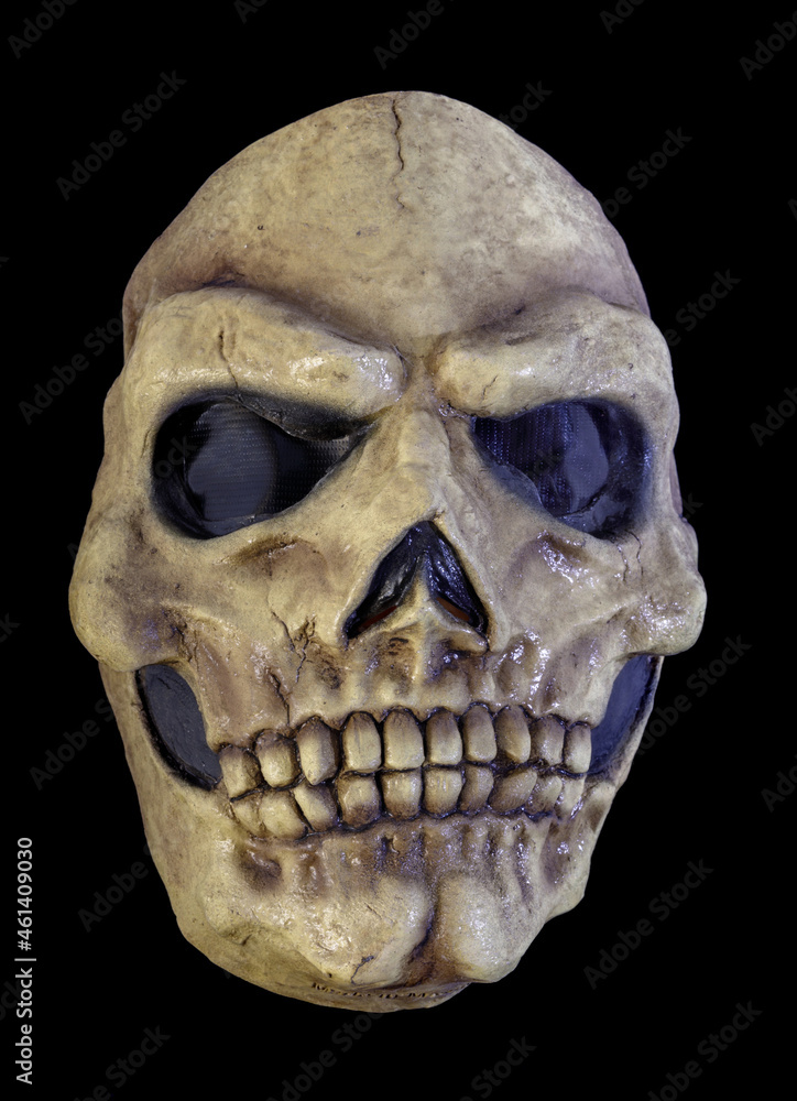 Obraz premium Yellowed Skull Mask Isolated Against Black Background