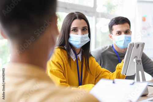 Young woman in medical masks working in office