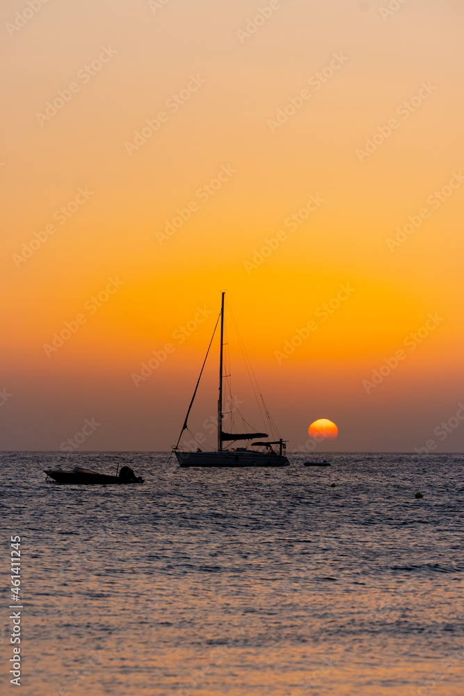 sunset by the beach with boats