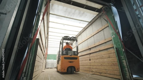 Forklift driver transports packaged water bottles in warehouse