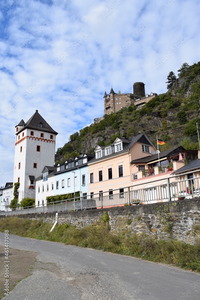 Promenade mit weißem Turm von Sankt Goarshausen mit Burg Katz darüber