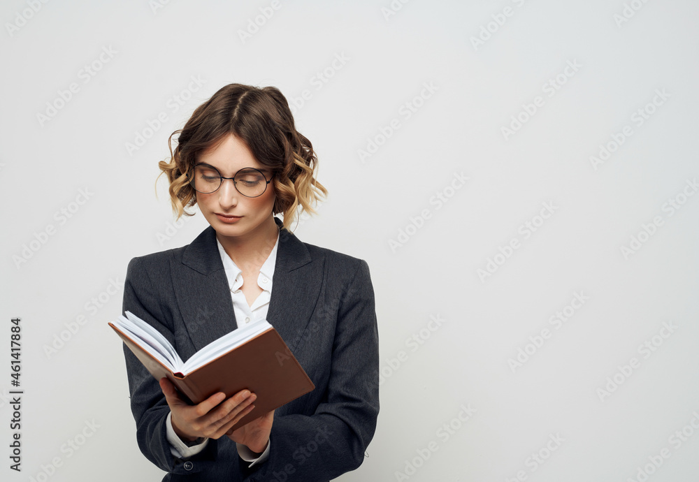 Businesswoman with a book in his hands light background Businesswoman with a book in his hands light background