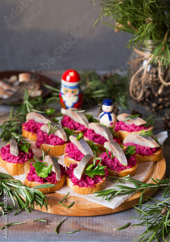 Sandwiches with beets and herring. New Year's snack with fish. Christmas food. Appetizing on New Year's Eve