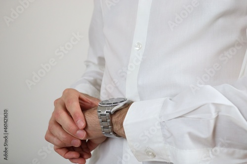 Elegant businessman looking at wristwatch 