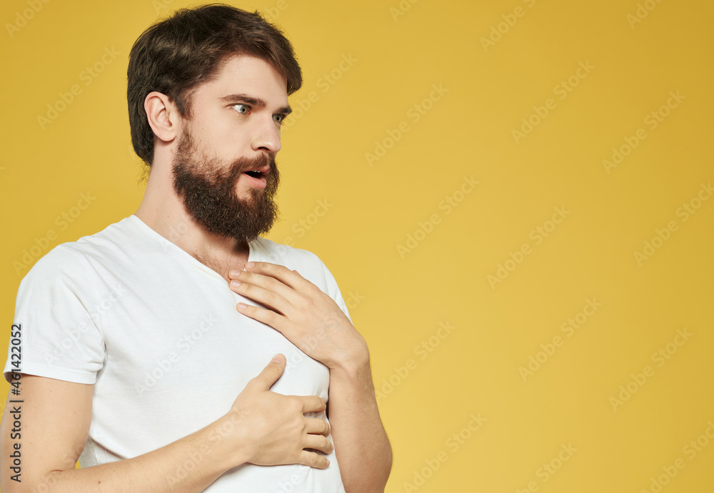 Man in a white t-shirt hand gestures anger yellow background Man in a white t-shirt hand gestures anger yellow background