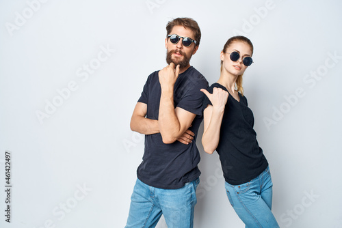 fashionable man and woman friendship communication romance wearing sunglasses light background
