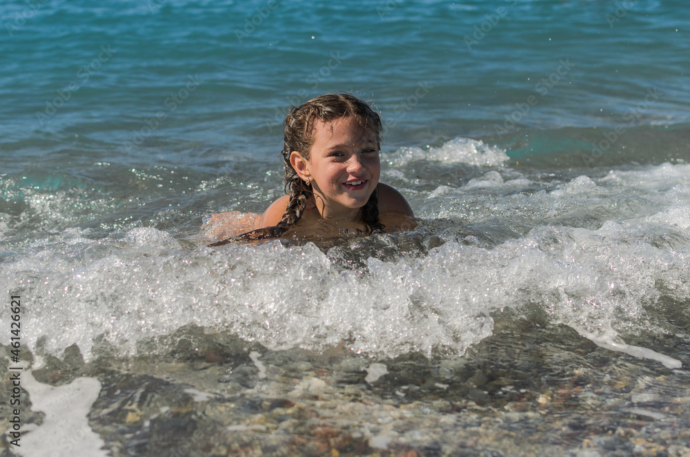Little happy adorable girl child swims in the sea and plays on the waves during the holidays on the sea coast
Little happy adorable girl child swims in the sea and plays on the waves during the holidays on the sea coast