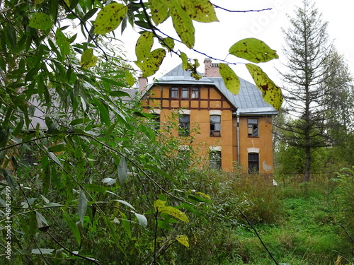 Fragment of a yellow house in a summer landscape 