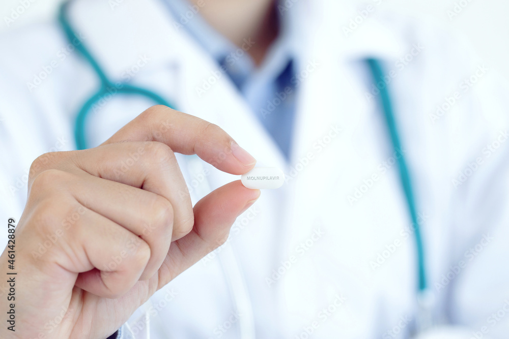 Close up female doctor with holding medicine Molnupiravir .Coronavirus covid-19 antiviral concept Close up female doctor with holding medicine Molnupiravir .Coronavirus covid-19 antiviral concept