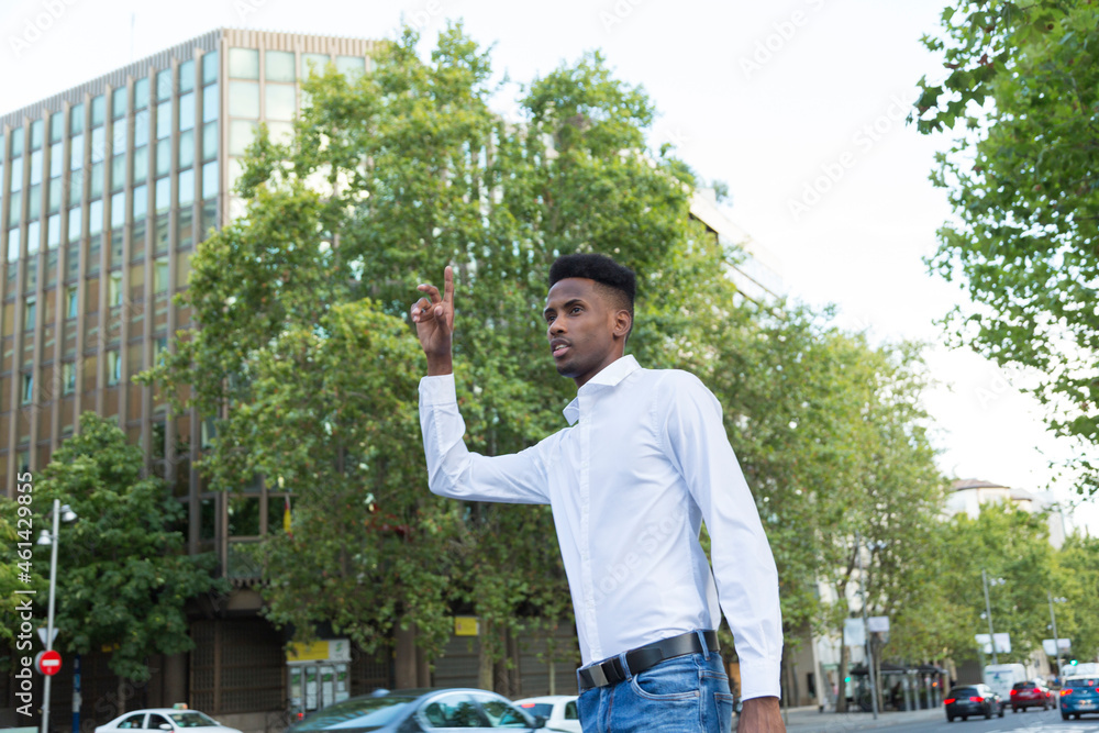 young black man calling a taxi by hand in casual clothes young black man calling a taxi by hand in casual clothes