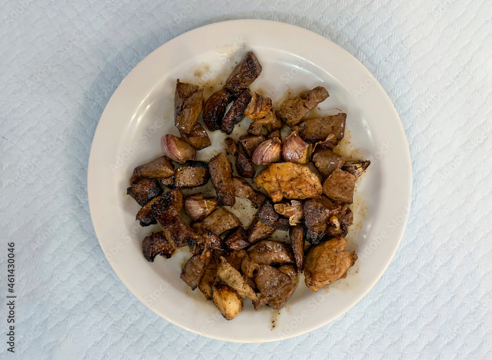 Fried lamb liver pieces and sliced lamb lung on a white plate Fried lamb liver pieces and sliced lamb lung on a white plate