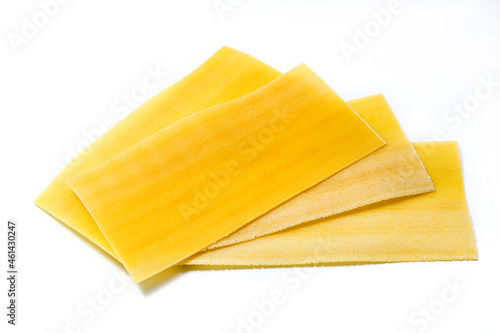 Uncooked raw lasagna pasta isolated on white background. Stack of dried uncooked lasagna 

pasta sheets