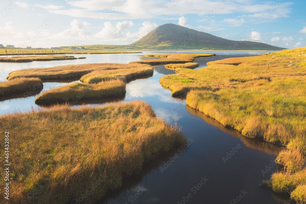Beautiful golden light on the salt marsh mountain landscape at Northton on the Isle of Lewis and Harris on the Outer Hebrides, Scotland, UK.