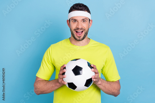 Photo of amazed excited cheerful man hold hand football game play championship isolated on blue color background © deagreez